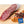 Load image into Gallery viewer, A close up picture of il porcellino salumi's Rosette De Lyon Salami on a cutting board with herbs and spices. Half of the salami is cut into slices while other half remains as a whole chub. Plus the Good Food Awards Finalist 2020 seal is placed in the lower right hand of the image.
