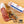 Load image into Gallery viewer, A picture of il porcellino salumi's Spiced Juniper Salami on a cutting board with herbs and spices shot from above. Once piece of salami is cut into slices while the other remains in packaging. Plus the Charcuterie Masters Grand Champion logo is placed in the lower right corner of the image.