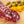 Load image into Gallery viewer, A close up of slices of hard salami with pistachios, fat, herbs and spices in it. The salami is on a cutting board with blurred pistachios and orange zest in the background.