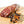 Load image into Gallery viewer, A chub of salami on a cutting board with half of it cut into bite size slices. Juniper berries and other herbs and spices are in the right foreground.