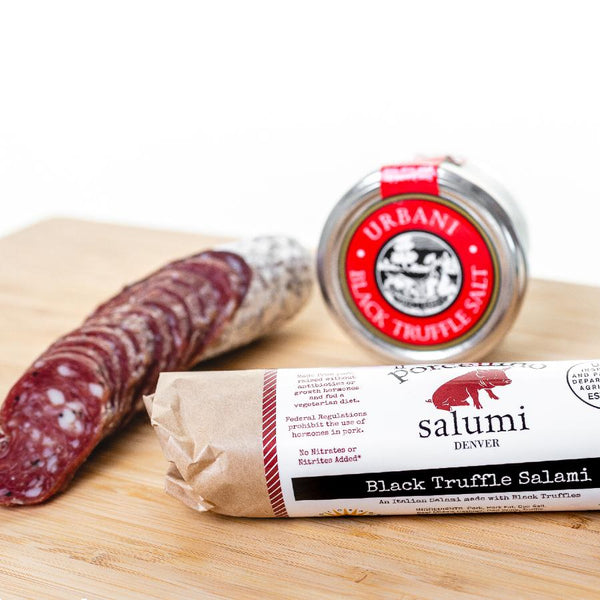 A product photo of il porcellino salumi's black truffle salami in packaging and cut into slices on a cutting board.