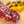 Load image into Gallery viewer, A close up of slices of hard salami with pistachios, fat, herbs and spices in it. The salami is on a cutting board with blurred pistachios and orange zest in the background.
