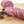 Load image into Gallery viewer, A chub of summer sausage on a cutting board with half cut into edible slices. The uncut half is in the background and herbs and spices are in the foreground.
